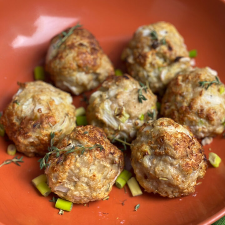 Air Fryer Chicken Meatballs in an orange bowl with green onions.