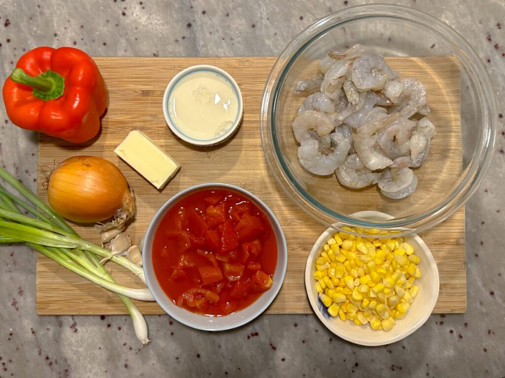 Ingredients for Shrimp and Tomato Bisque with Sweet Corn including red peppers, onions, sweet corn, raw shrimp, diced tomatoes, butter, flour, and green onions.