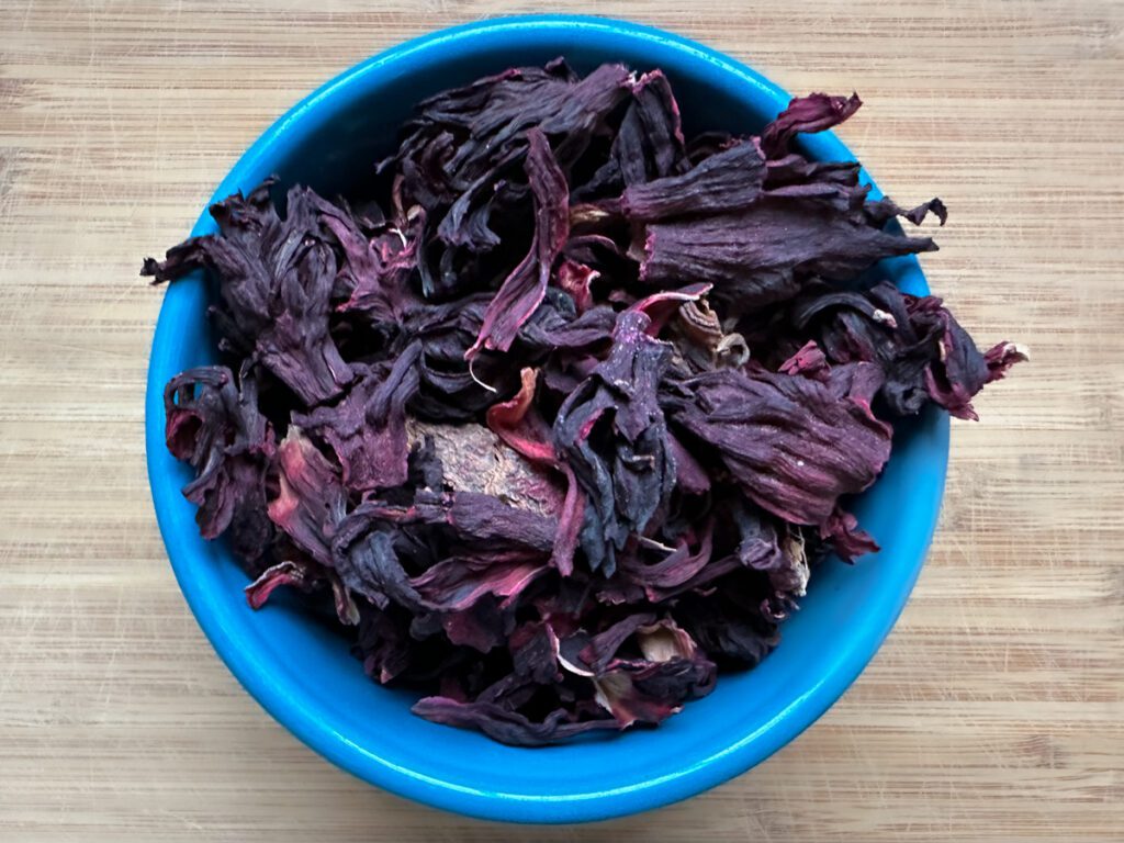 Dried hibiscus leaves in a blue bowl.